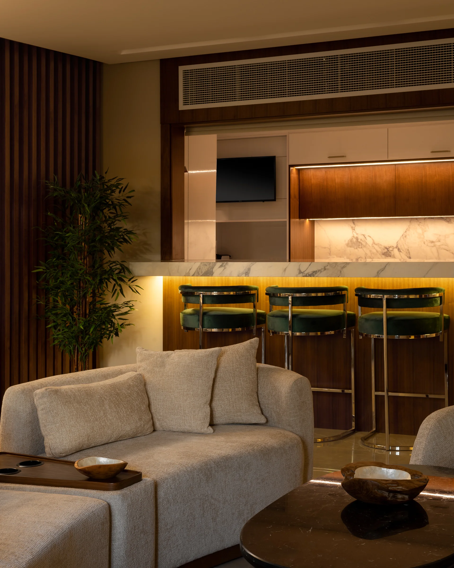Living room open to the kitchen counter, yellow stools beyond.