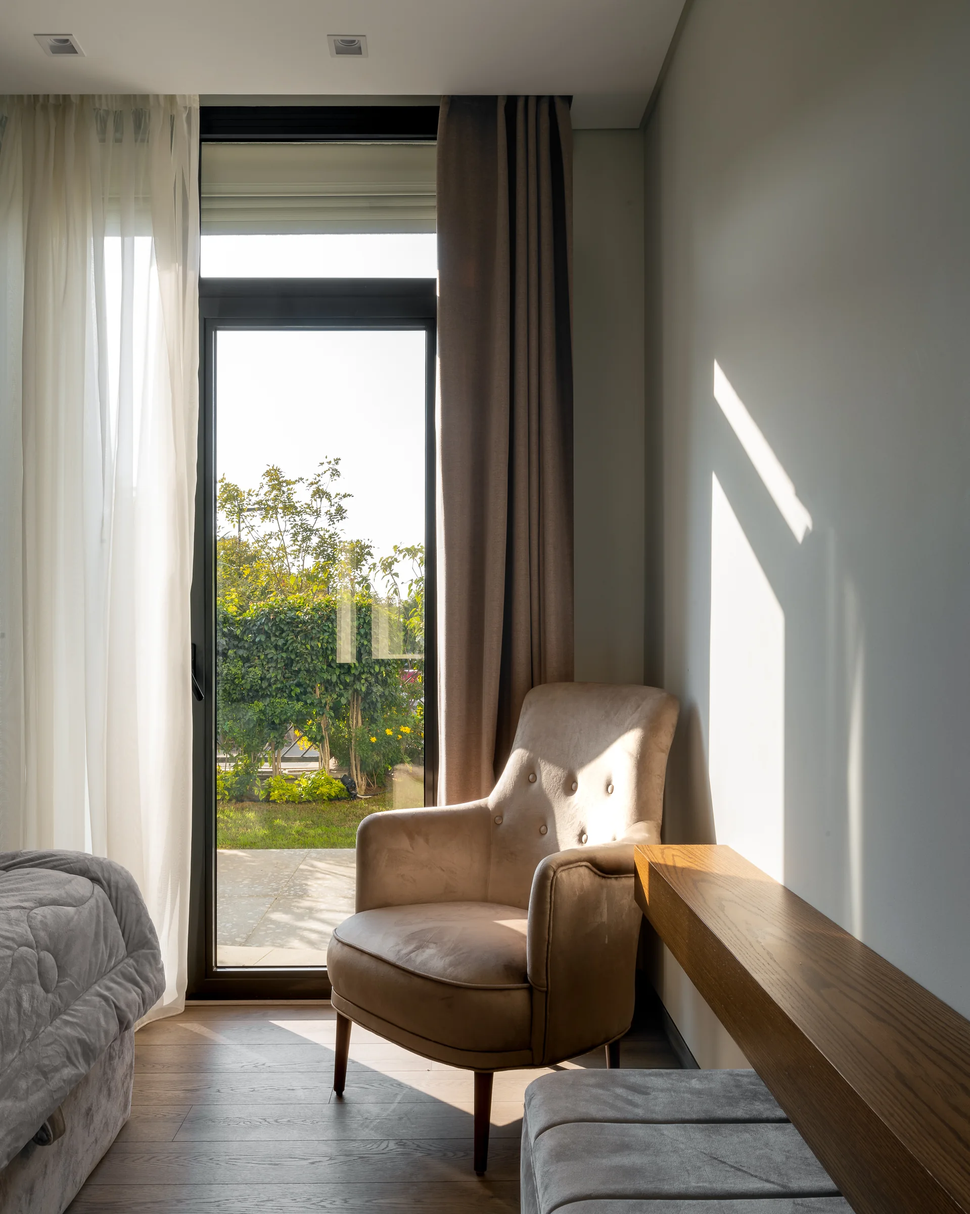 Bedroom corner with an armchair in morning light.