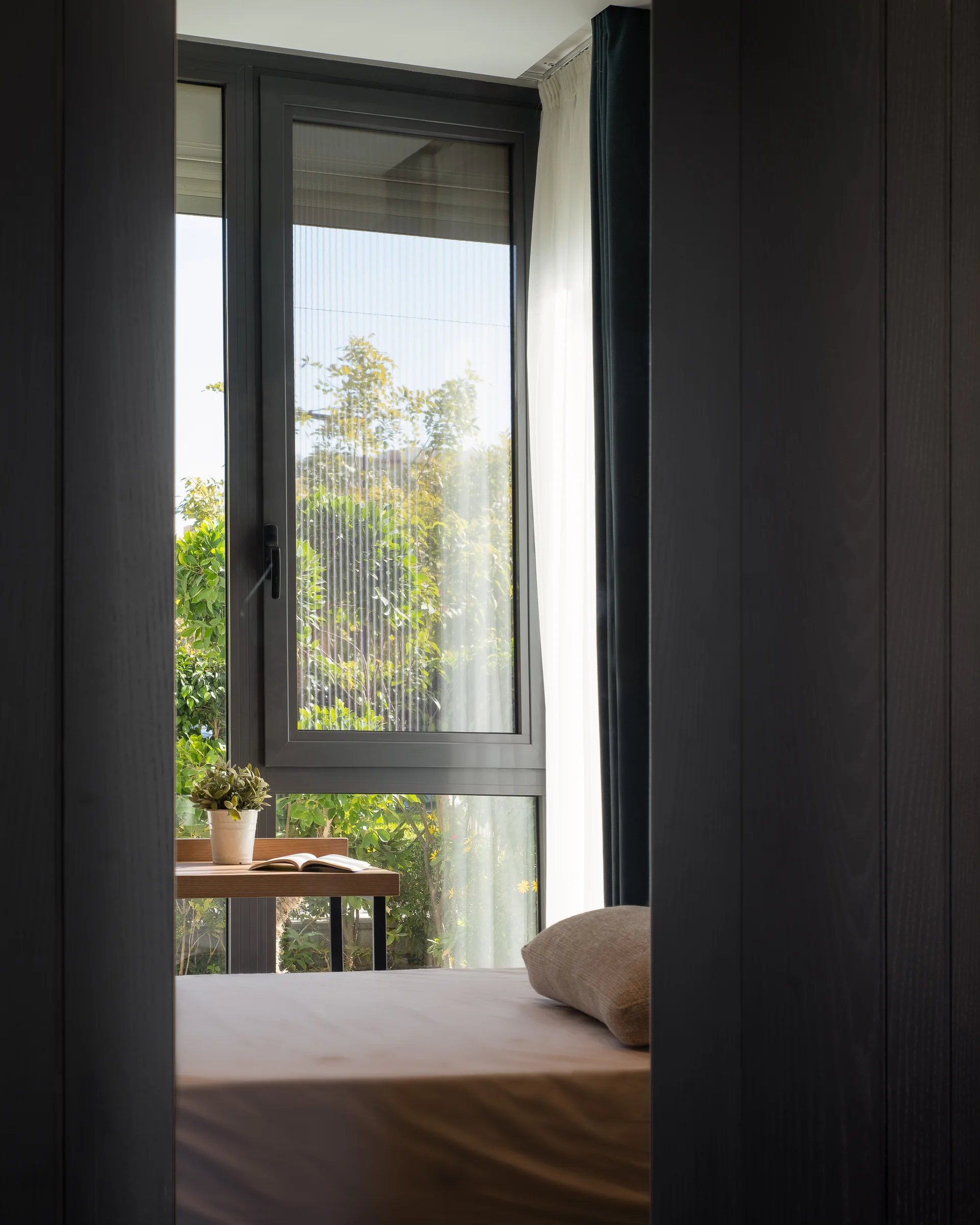 Bedroom window with the desk and the garden beyond.