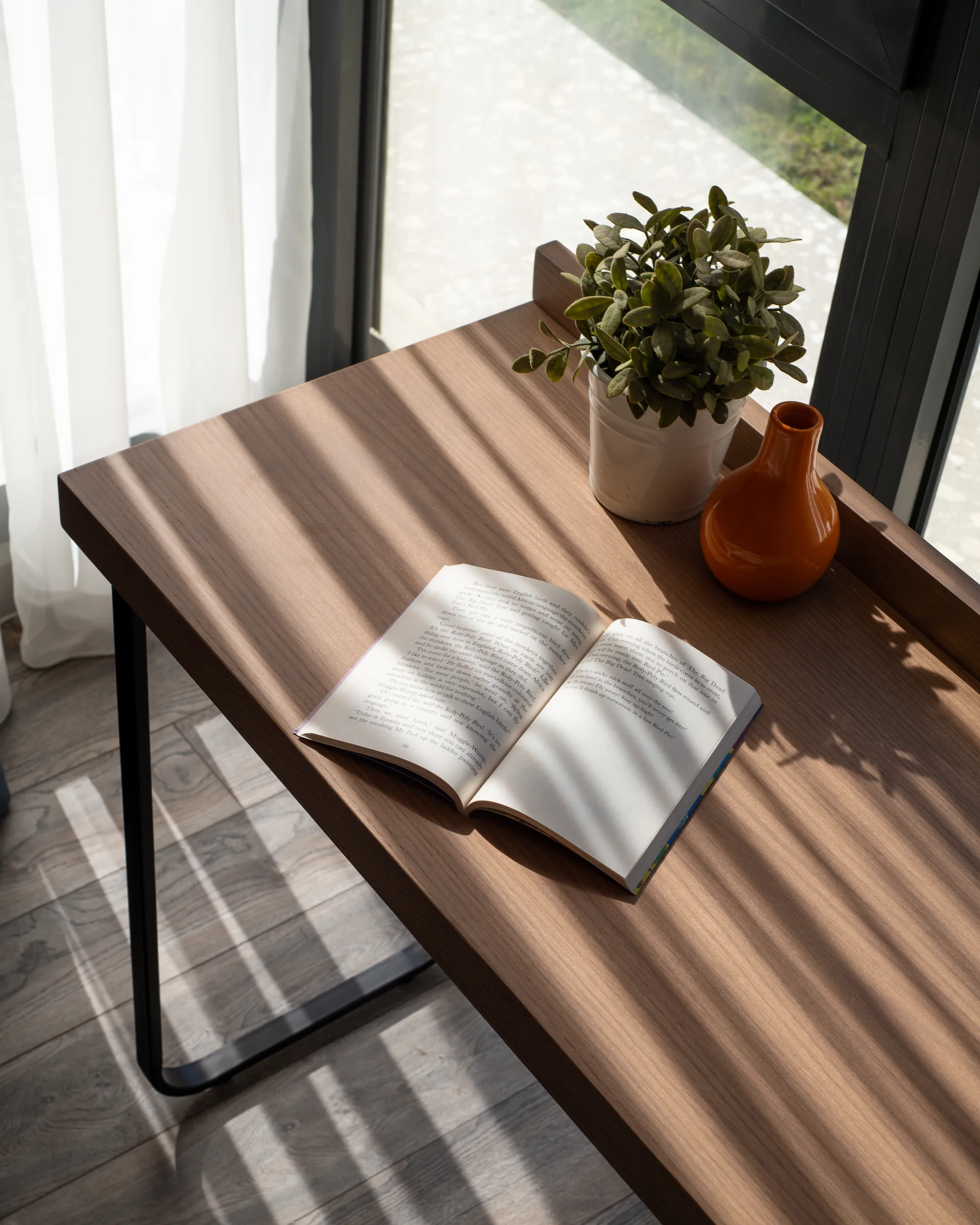 The same desk looking down, shadow across the timber.