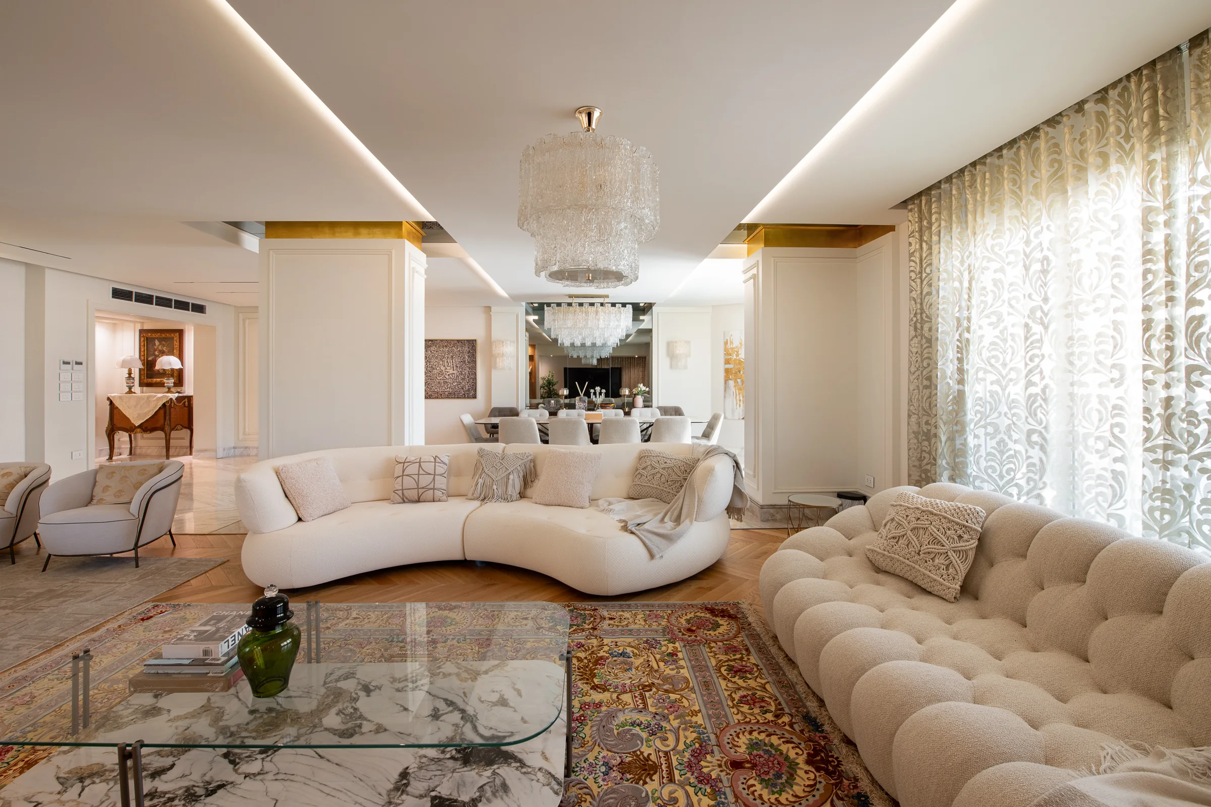 Reception with a curved sofa under a crystal chandelier.