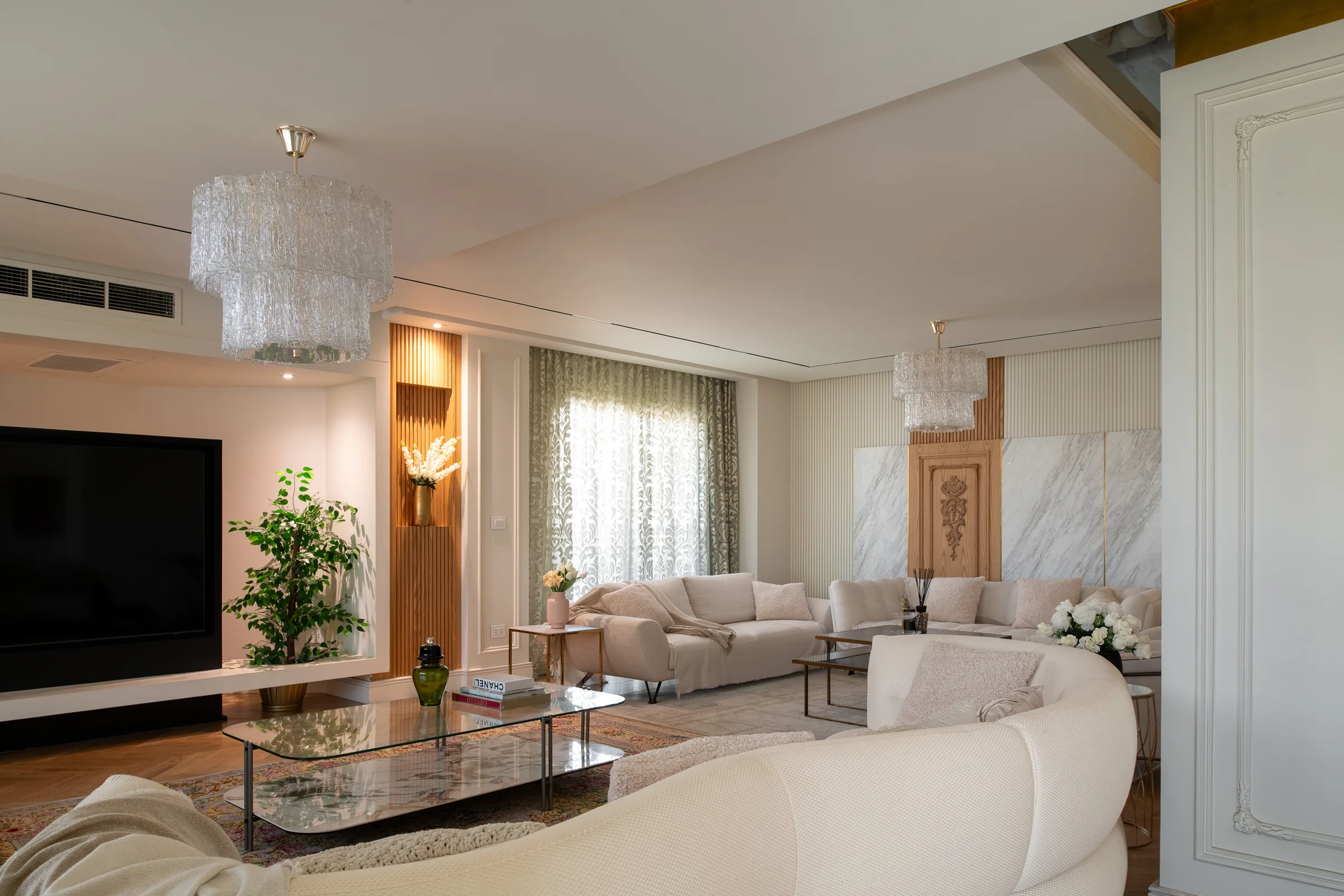 The room from the far end, chandelier over the glass table.