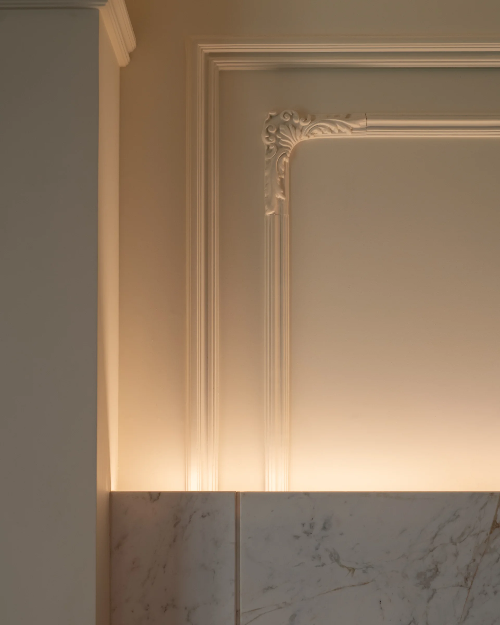 Detail: plaster panelling meeting a marble skirting.