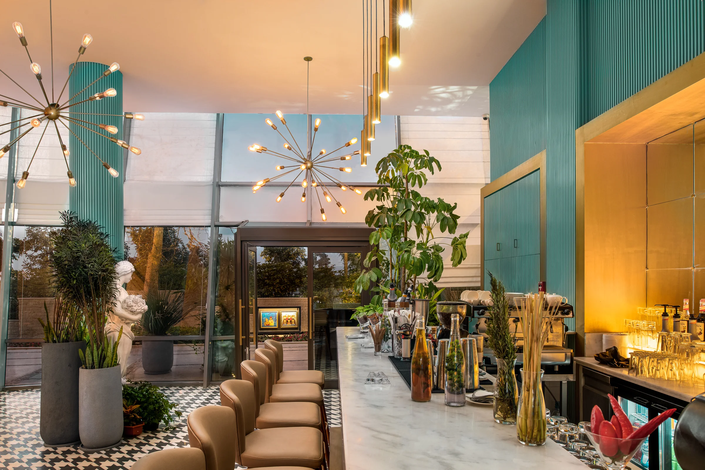 The dining room under its brass chandelier, terrace beyond the glass.