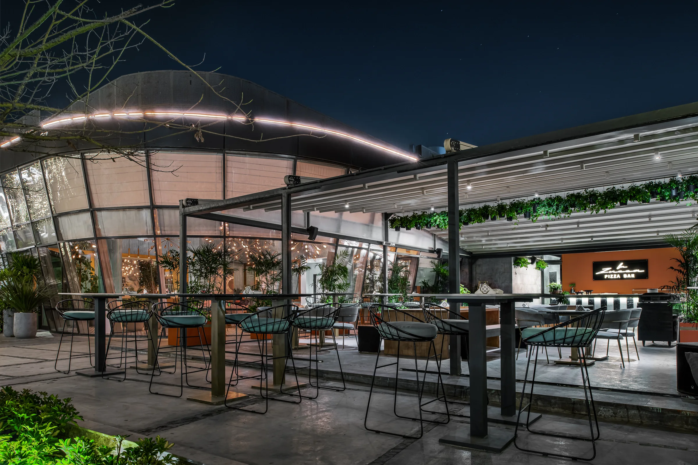 The terrace at dusk under its curved roof.