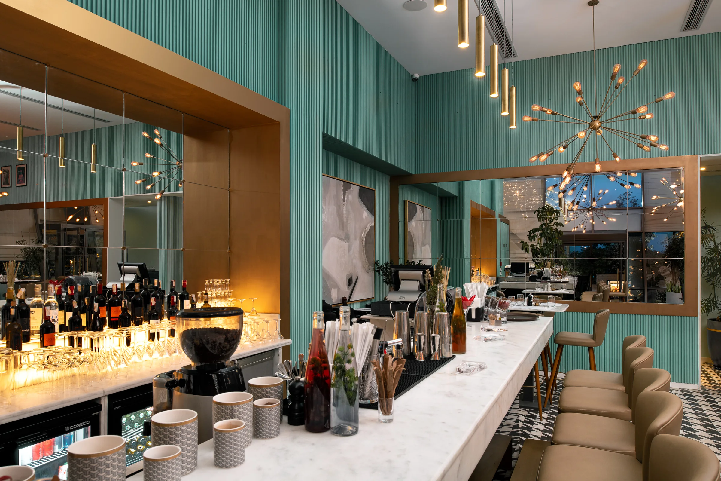 Bottle display and marble counter under low brass pendants.