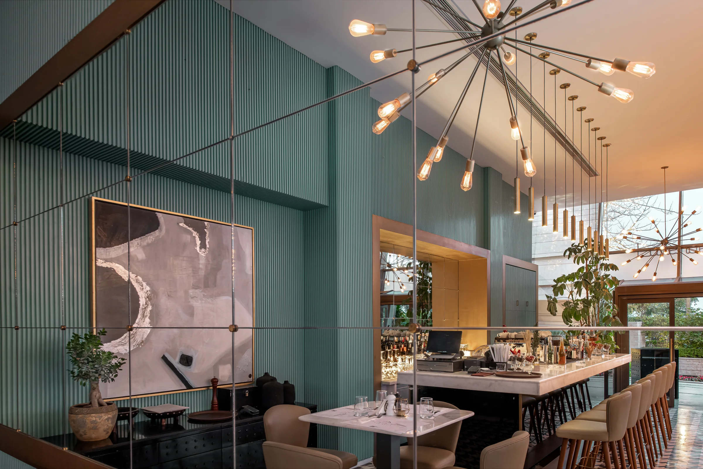 Banquette dining with artwork and mirrored panelling.
