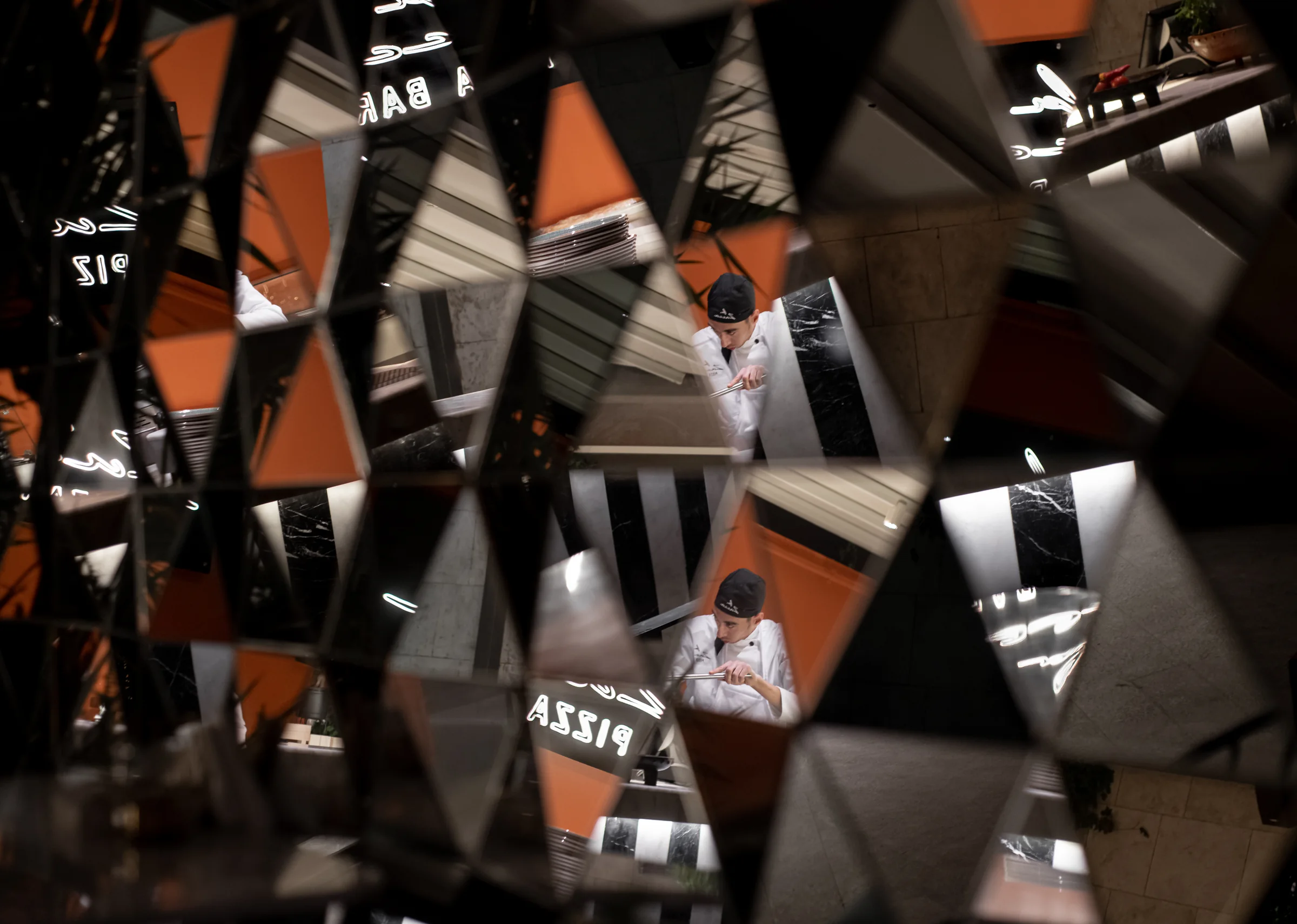 Faceted mirror panels breaking the room into fragments.