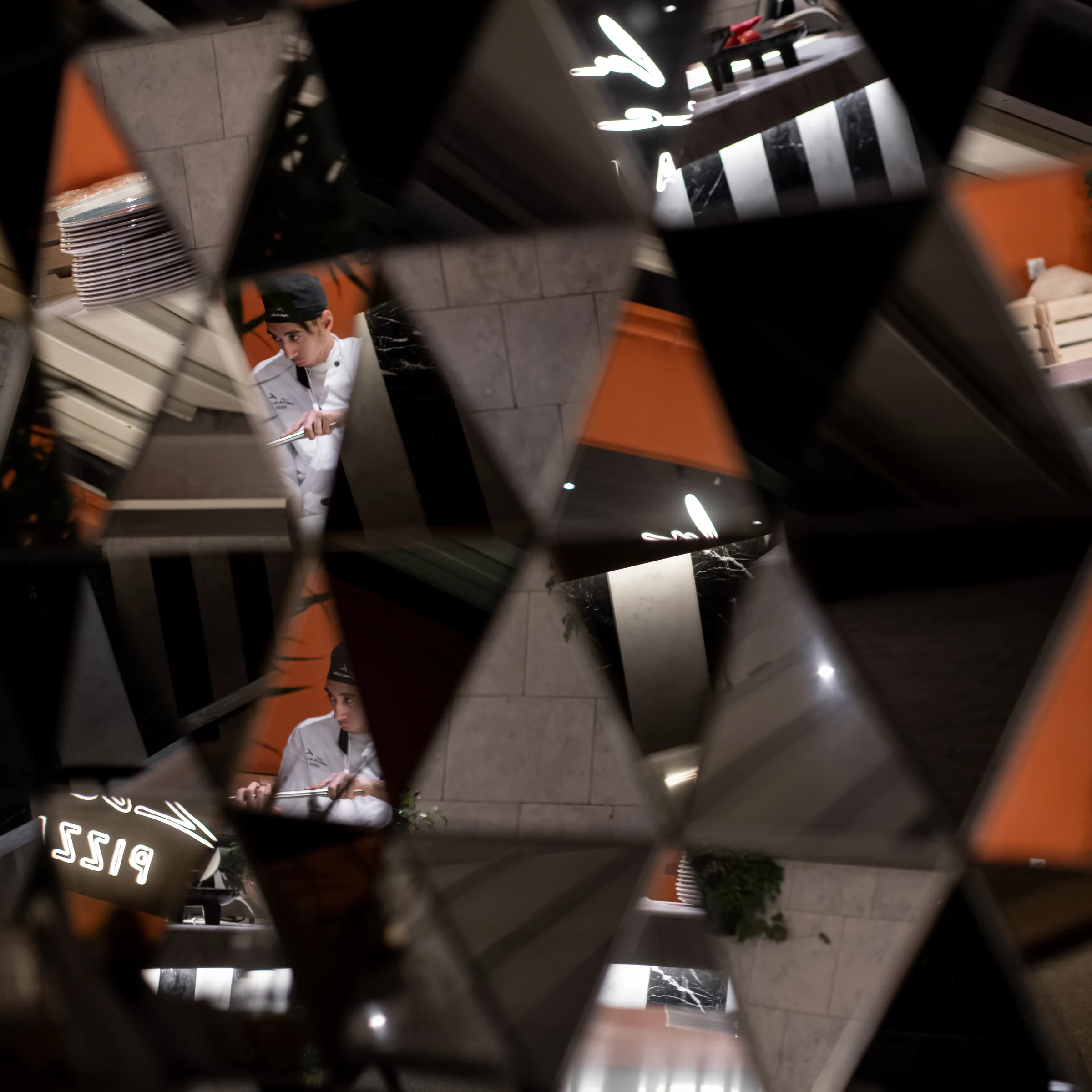 The same panels closer, the kitchen crew reflected.